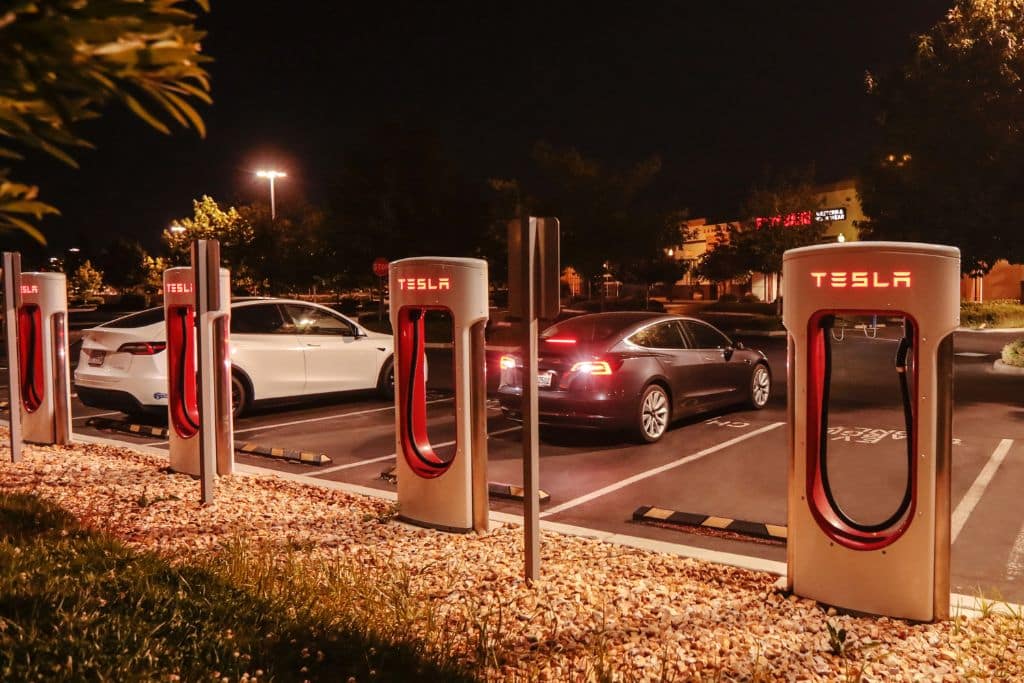 A Tesla electric vehicle charging station at night.